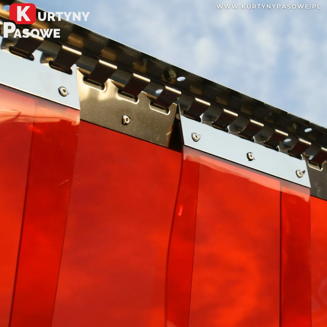 Czerwone pasy spawalnicze PCV zawieszone na listwie grzebieniowej INOX, montaż zewnętrzny na tle nieba